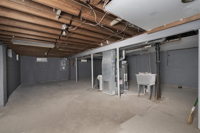 unfinished below grade area with water heater, a sink, and heating unit