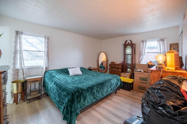 bedroom featuring light wood-style flooring and a textured ceiling