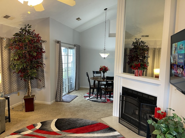 carpeted living area with a fireplace with flush hearth, visible vents, and vaulted ceiling