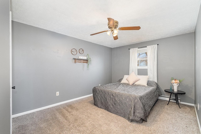 bedroom featuring a textured ceiling, carpet flooring, baseboards, and ceiling fan