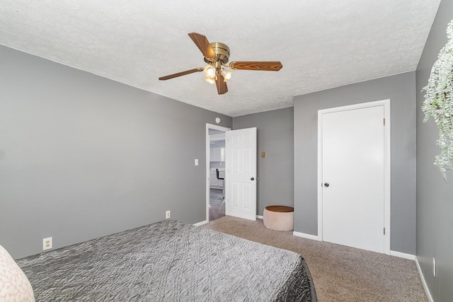 carpeted bedroom featuring a textured ceiling and ceiling fan