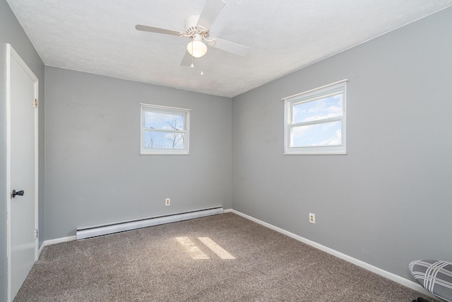 unfurnished room featuring a baseboard heating unit, carpet flooring, baseboards, and a wealth of natural light