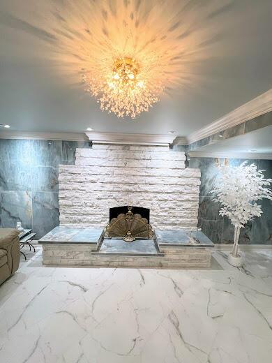 basement with marble finish floor, crown molding, and recessed lighting