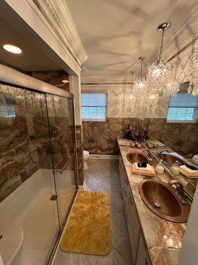 full bathroom with a stall shower, tile walls, and a sink