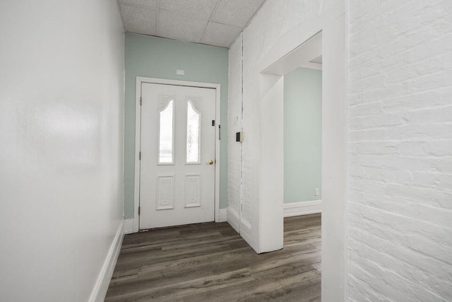 entrance foyer with a drop ceiling, baseboards, and wood finished floors