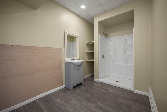 full bathroom featuring a shower, vanity, wood finished floors, and a paneled ceiling