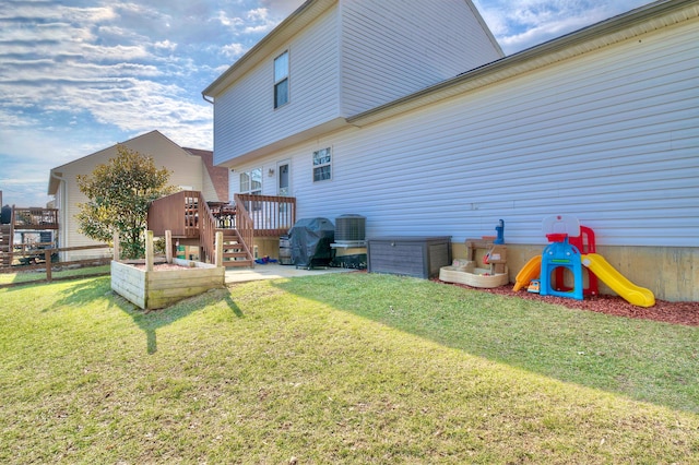 exterior space with a yard, cooling unit, and a wooden deck