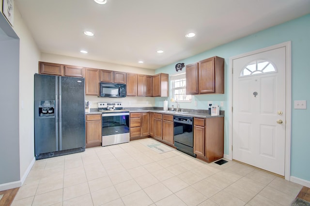 kitchen with a sink, baseboards, black appliances, and recessed lighting