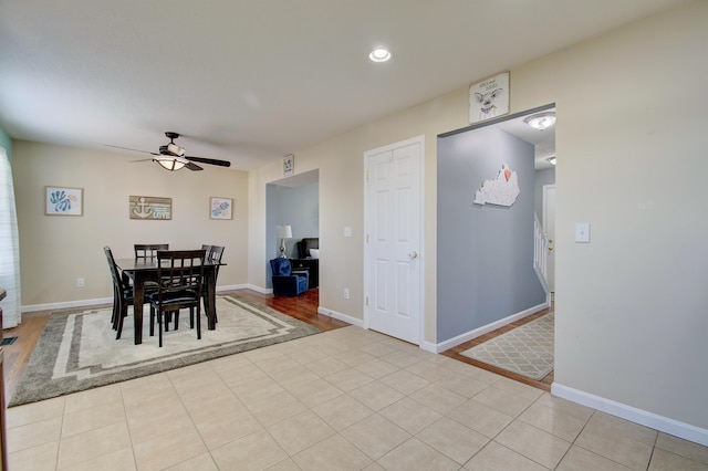 dining room with light tile patterned flooring, baseboards, and ceiling fan