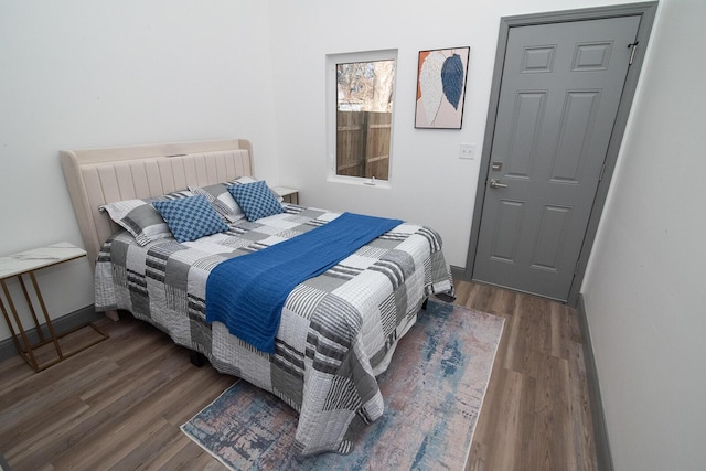 bedroom with wood finished floors and baseboards