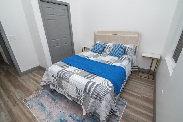 bedroom with baseboards and wood finished floors