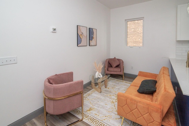 living area with baseboards and wood finished floors