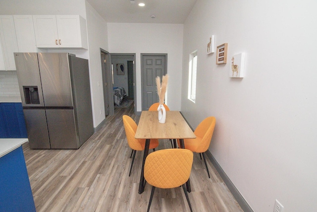 dining space with recessed lighting, light wood-type flooring, and baseboards