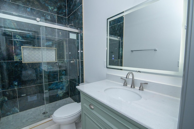 bathroom with toilet, a shower stall, and vanity