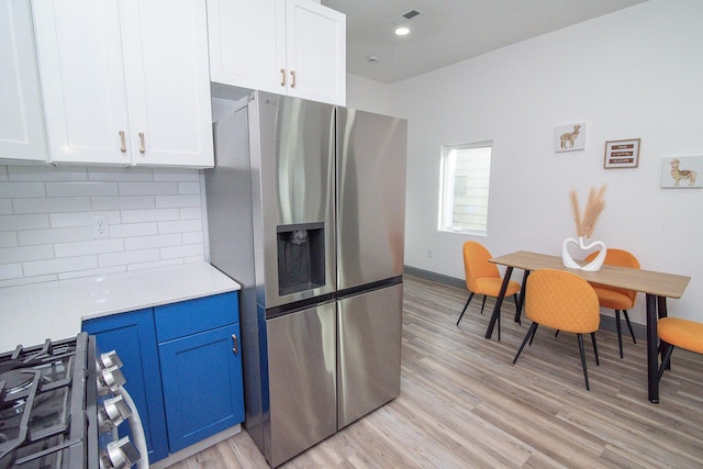 kitchen featuring stainless steel appliances, light countertops, light wood finished floors, and decorative backsplash