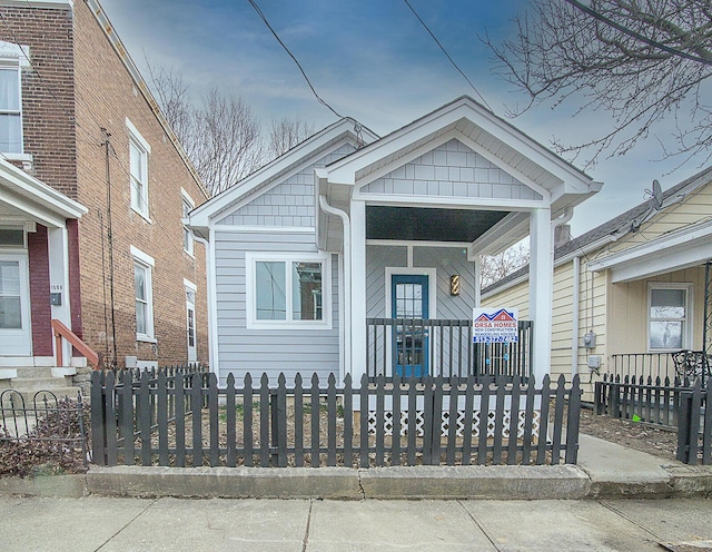 view of front of property with covered porch and a fenced front yard