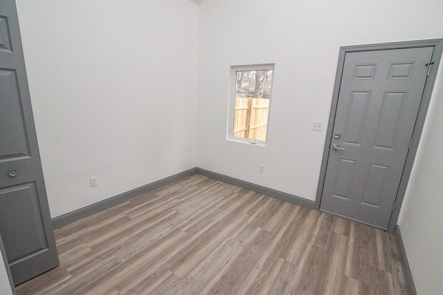 empty room with baseboards and wood finished floors