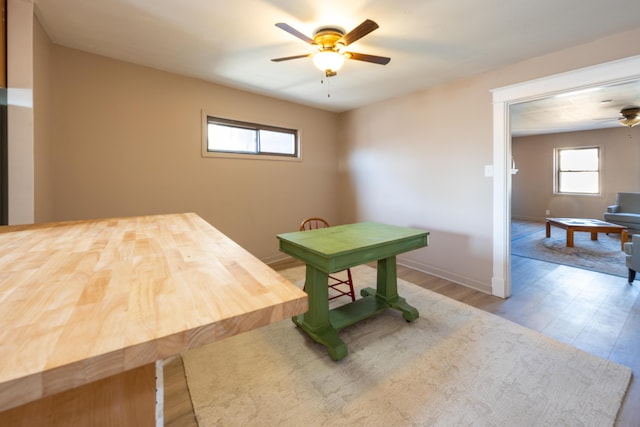 dining space featuring baseboards, wood finished floors, and ceiling fan