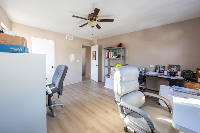 home office featuring light wood-type flooring, visible vents, baseboards, and ceiling fan