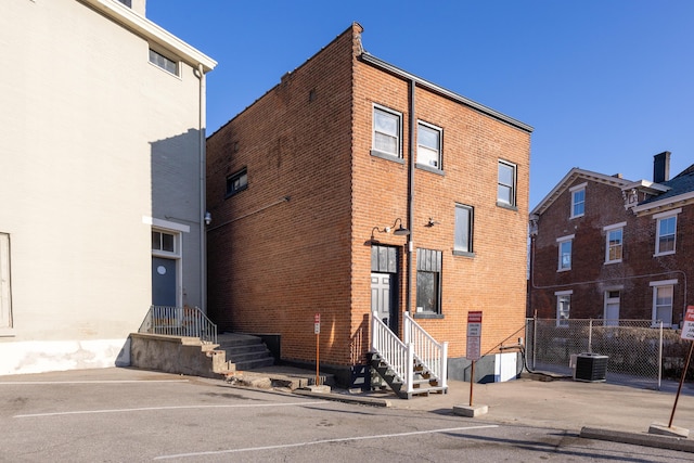 view of building exterior featuring entry steps and fence