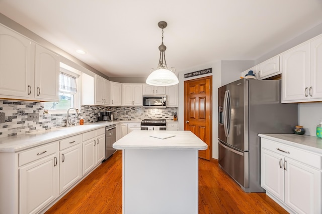 kitchen with light wood-style flooring, a kitchen island, appliances with stainless steel finishes, and a sink