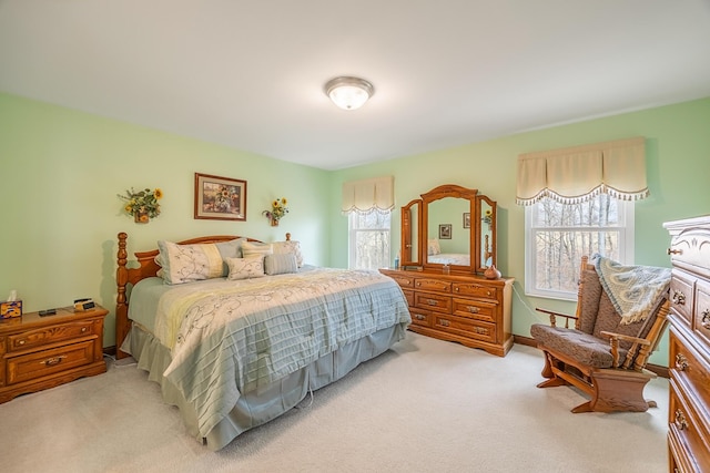 bedroom featuring light carpet and baseboards