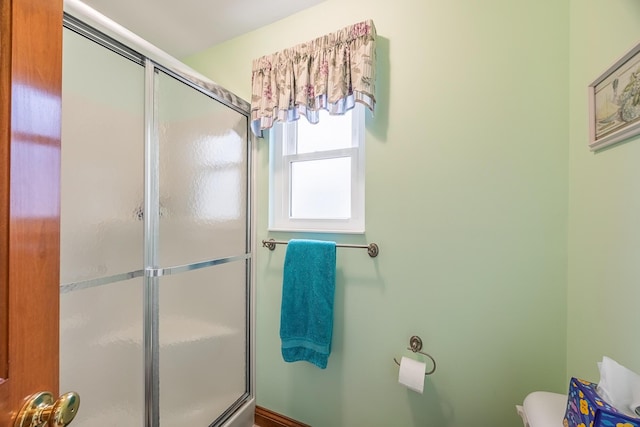 bathroom with toilet and a shower with shower door