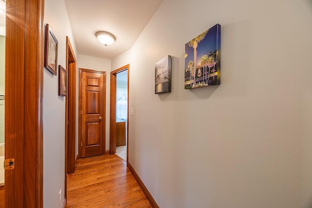 hallway with light wood finished floors and baseboards