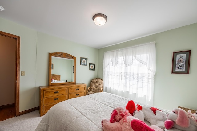 bedroom with light carpet and baseboards