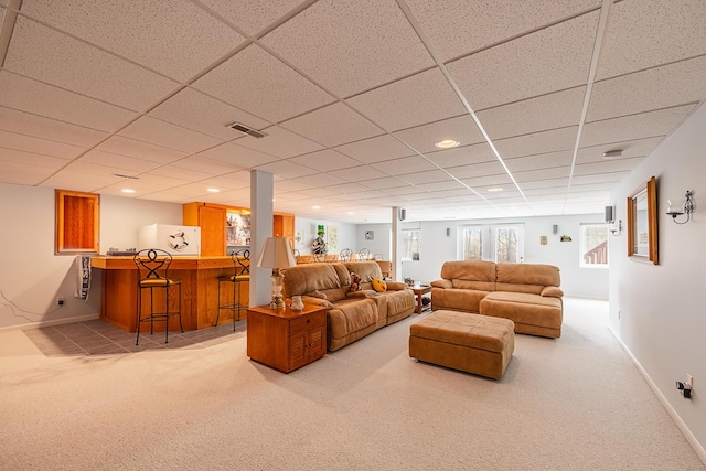 living area with a dry bar, baseboards, visible vents, and light colored carpet