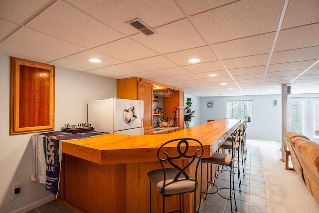 bar featuring recessed lighting, visible vents, freestanding refrigerator, a bar, and carpet