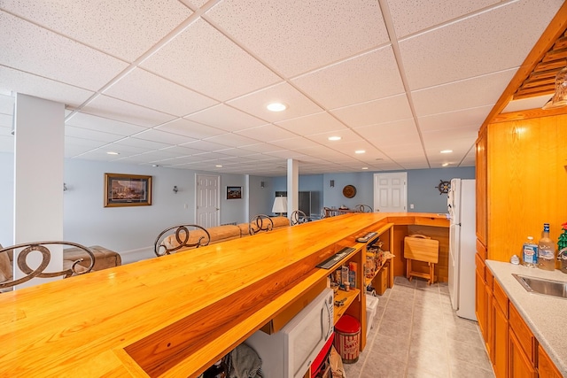 bar featuring recessed lighting, a drop ceiling, and freestanding refrigerator