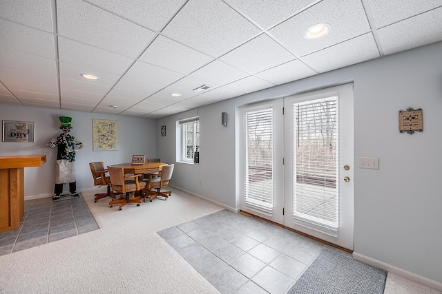 dining space with a drop ceiling, carpet flooring, visible vents, and baseboards