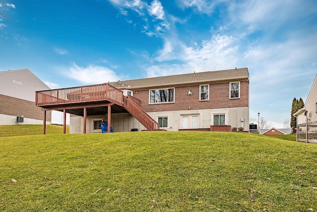 back of property featuring stairs, a deck, a lawn, and brick siding