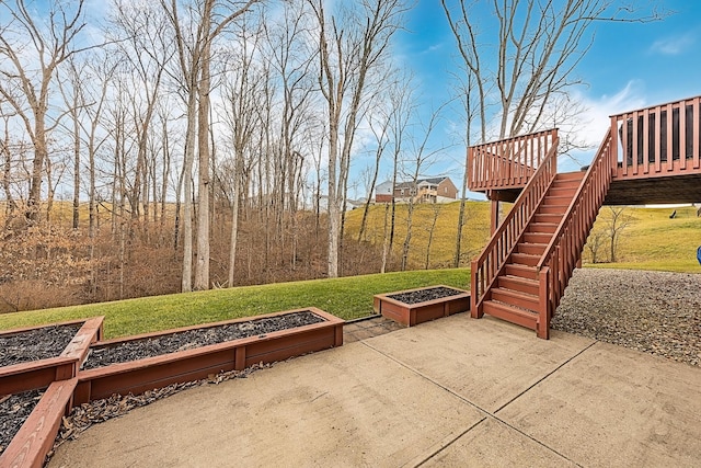 view of patio / terrace featuring stairs, a vegetable garden, and a deck