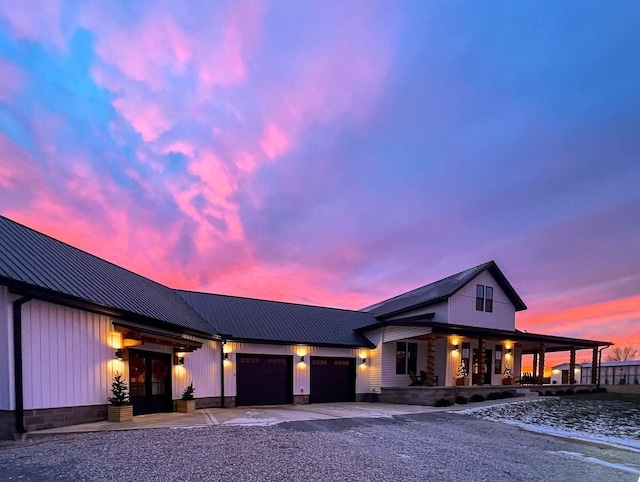 view of front facade featuring metal roof, driveway, and an attached garage