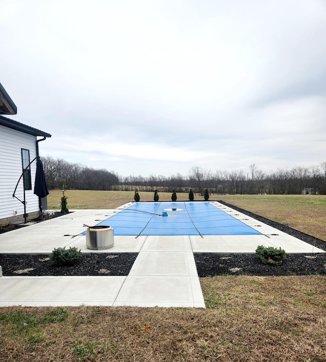 view of pool with a covered pool, a patio area, and a yard