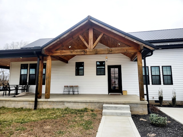 doorway to property with metal roof and a porch