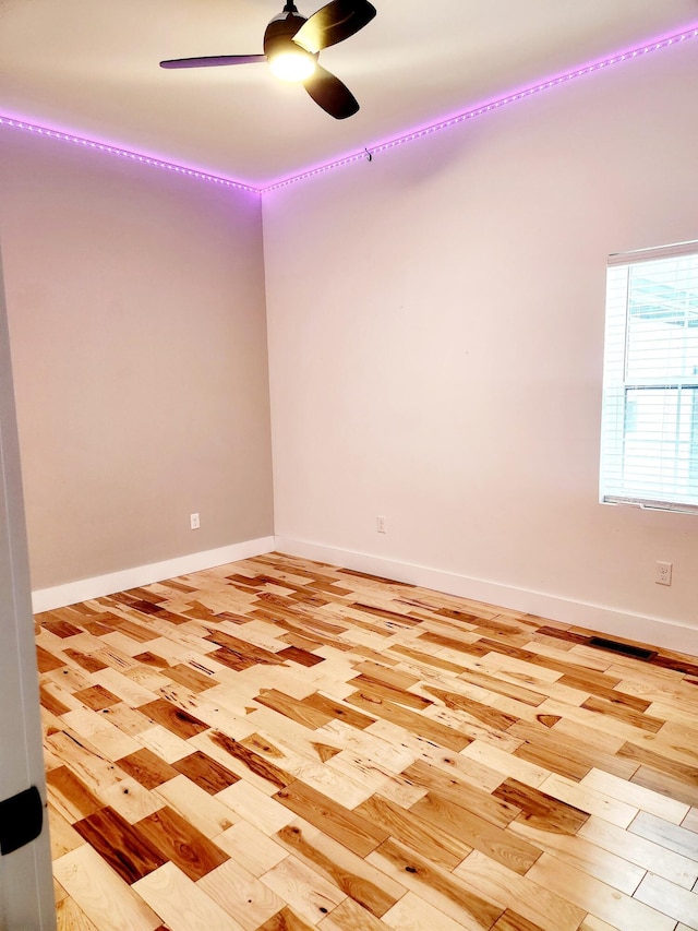 empty room featuring baseboards, light wood-style floors, and ceiling fan