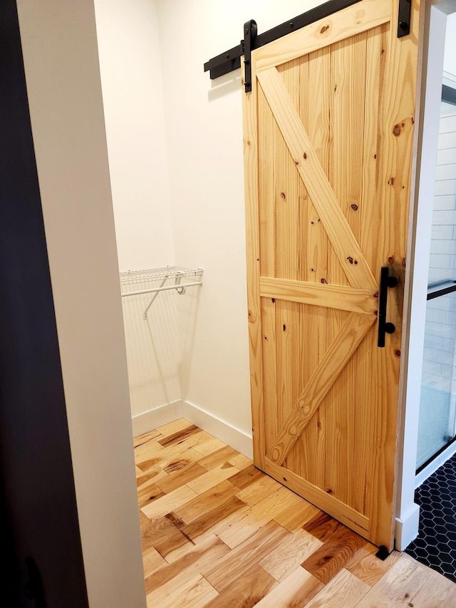 interior space featuring light wood-type flooring and a barn door