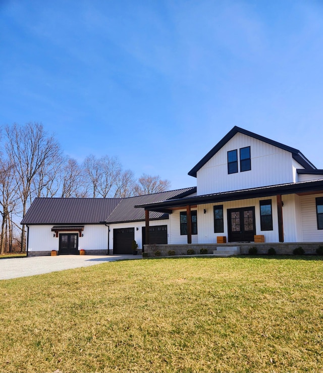 modern inspired farmhouse featuring a garage, a front lawn, metal roof, and driveway