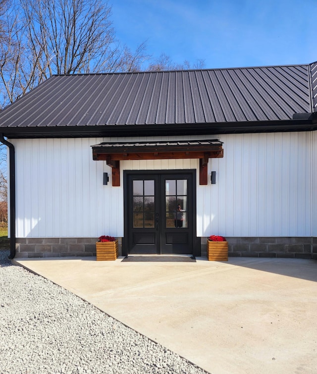 doorway to property with french doors, metal roof, and a patio