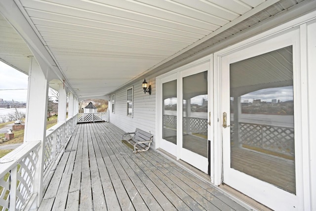 wooden deck with a porch and french doors