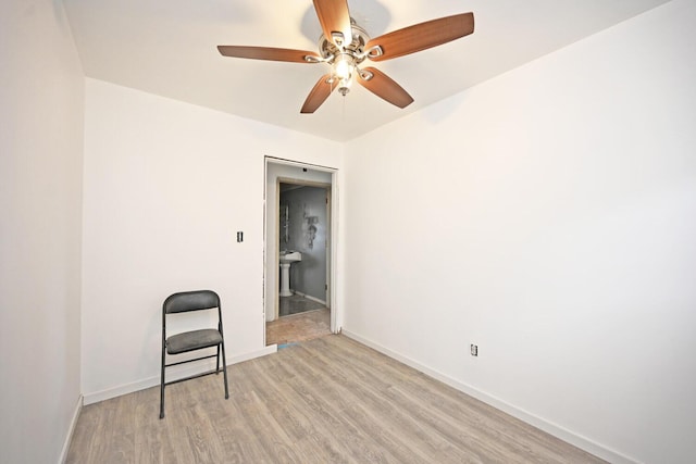 empty room featuring a ceiling fan, light wood-style flooring, and baseboards