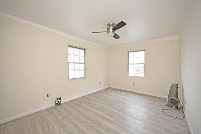 empty room featuring baseboards, light wood-style floors, ornamental molding, and a healthy amount of sunlight