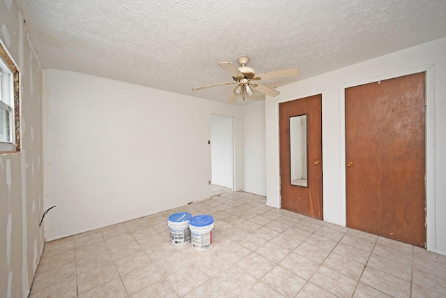 unfurnished room featuring ceiling fan and a textured ceiling