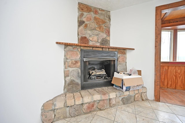 details with a textured ceiling and a stone fireplace