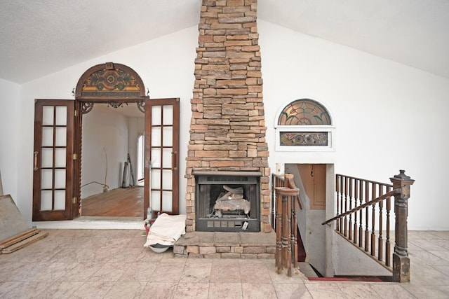 unfurnished living room featuring lofted ceiling, french doors, and a fireplace