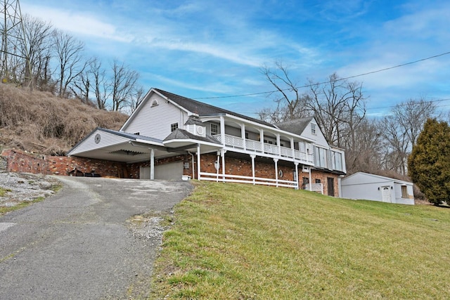 view of front of property with driveway, brick siding, an attached garage, and a front yard