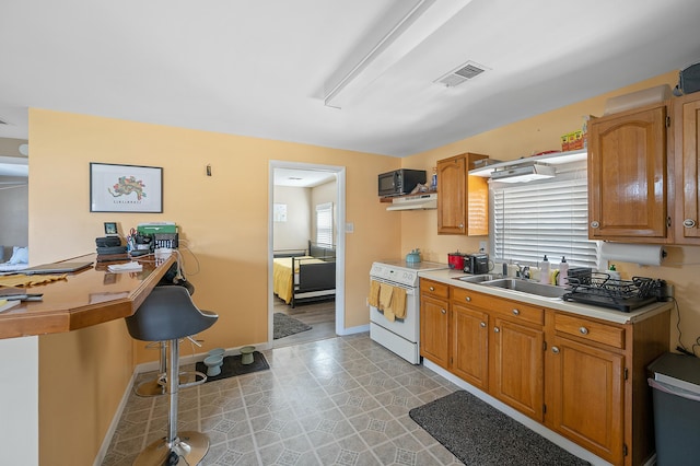 kitchen featuring black microwave, light countertops, a sink, and white electric range oven